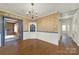 Dining area with hardwood floors, vintage wallpaper, and a unique door detail at 5876 Wedgewood Dr, Charlotte, NC 28210