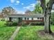 Charming single-story home with brick facade, lush green lawn, and mature landscaping, creating a welcoming curb appeal at 5876 Wedgewood Dr, Charlotte, NC 28210