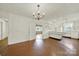 Open-concept space features hardwood floors, white cabinetry, and vintage chandelier at 5876 Wedgewood Dr, Charlotte, NC 28210