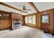 Cozy living room with wood paneling, brick fireplace, ceiling beams, and an exit door at 5876 Wedgewood Dr, Charlotte, NC 28210