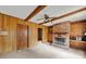 Cozy room with wood paneling, brick fireplace, ceiling beams, and built-in shelving at 5876 Wedgewood Dr, Charlotte, NC 28210