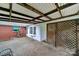 Covered patio featuring brick flooring, an intricate wood-beam ceiling, and an attractive lattice fence for privacy at 5876 Wedgewood Dr, Charlotte, NC 28210