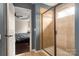 An open bathroom with a tiled shower and view into bedroom offers convenience and style at 5951 Carrollton Ln, Charlotte, NC 28210