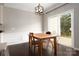 A dining area featuring a wood table, matching chairs, an overhead light fixture, and sliding glass doors to the outside at 5951 Carrollton Ln, Charlotte, NC 28210
