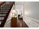 Welcoming foyer with hardwood floors, elegant wainscoting, staircase, and a view into the living room at 5951 Carrollton Ln, Charlotte, NC 28210