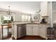 Bright kitchen featuring a stainless steel dishwasher, white cabinetry, and hardwood floors at 5951 Carrollton Ln, Charlotte, NC 28210