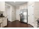 Spacious kitchen with stainless steel refrigerator, white cabinetry, and hardwood flooring at 5951 Carrollton Ln, Charlotte, NC 28210
