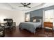 A spacious bedroom featuring a tray ceiling, a ceiling fan, wood accent wall and dark wood flooring at 5951 Carrollton Ln, Charlotte, NC 28210