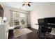 This office features dark wood floors, neutral walls, a large window that adds natural light, and a ceiling fan at 5951 Carrollton Ln, Charlotte, NC 28210