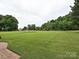 Spacious backyard with well-manicured lawn and view of neighborhood homes at 6144 Abergele Ln, Matthews, NC 28104
