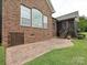 Brick patio and exterior of home featuring a screened porch and lush landscaping at 6144 Abergele Ln, Matthews, NC 28104