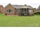Brick home exterior with manicured landscaping, patio, and cozy screened-in porch at 6144 Abergele Ln, Matthews, NC 28104
