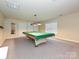 Finished basement with a billiards table, neutral carpet, and ample space for recreation at 6144 Abergele Ln, Matthews, NC 28104