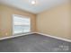 Cozy bedroom with neutral carpet, large window for natural light, and a spacious layout at 6144 Abergele Ln, Matthews, NC 28104