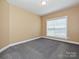 Neutral bedroom featuring a large window, neutral walls, and gray carpet flooring at 6144 Abergele Ln, Matthews, NC 28104