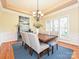 Elegant dining room with tray ceiling, stylish chandelier and shuttered windows at 6144 Abergele Ln, Matthews, NC 28104