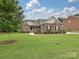 Beautiful brick home with well-maintained lawn, shrubs, and inviting curb appeal at 6144 Abergele Ln, Matthews, NC 28104