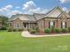 Charming brick home with manicured lawn and inviting walkway to the front door at 6144 Abergele Ln, Matthews, NC 28104