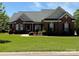 Charming brick home with lush green lawn and well-manicured landscaping at 6144 Abergele Ln, Matthews, NC 28104