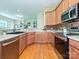 Modern kitchen with stainless steel appliances, hardwood floors, and open to living area at 6144 Abergele Ln, Matthews, NC 28104