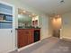 Basement wet bar with wooden cabinets, granite countertop, mirrored backsplash, and a mini fridge at 6144 Abergele Ln, Matthews, NC 28104