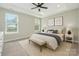Bright bedroom with tray ceiling, ceiling fan, and large windows providing natural light at 6529 Jepson Ct, Charlotte, NC 28214