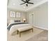 Well-lit bedroom featuring neutral decor, bench, and a glimpse into the bathroom at 6529 Jepson Ct, Charlotte, NC 28214