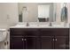 Bathroom featuring double sink vanity, framed mirror, and hardwood floors at 6816 Pennyroyal Way, Charlotte, NC 28216