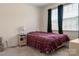Bedroom featuring neutral carpet, side table, and window covered with dark curtains at 6816 Pennyroyal Way, Charlotte, NC 28216