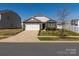 Charming home featuring a stone facade, attached garage, well-kept lawn, and inviting curb appeal at 6816 Pennyroyal Way, Charlotte, NC 28216