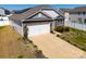 A side aerial view of a home with a driveway, garage, and a partial view of the lawn at 6816 Pennyroyal Way, Charlotte, NC 28216