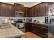 Stylish kitchen with dark cabinets, stainless steel appliances, granite countertops and hardwood floors at 6816 Pennyroyal Way, Charlotte, NC 28216