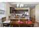 Eat-in kitchen featuring dark wood cabinetry, stainless steel appliances, and an island at 6816 Pennyroyal Way, Charlotte, NC 28216