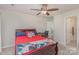 Bedroom featuring a ceiling fan, a desk area, and an adjacent bathroom, all accented with neutral carpeting at 715 Saddlebred Ln, Locust, NC 28097