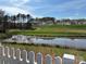 Scenic view of a pond with white picket fence and homes in the background at 715 Saddlebred Ln, Locust, NC 28097