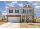 Two-story home featuring a two-car garage, stone accents, and a well-maintained front yard at 715 Saddlebred Ln, Locust, NC 28097