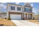 Charming exterior view of the two-story home showcasing the stone and siding facade and driveway at 715 Saddlebred Ln, Locust, NC 28097