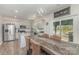 Bright kitchen and dining area, featuring modern appliances, white cabinets, and stylish lighting at 715 Saddlebred Ln, Locust, NC 28097