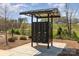 Community mailbox kiosk with metal covering, set in a landscaped area with trees and shrubs at 715 Saddlebred Ln, Locust, NC 28097