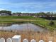 Community pond view from behind a white picket fence, showcasing the residential neighborhood at 715 Saddlebred Ln, Locust, NC 28097
