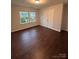 Bright bedroom featuring hardwood floors, natural light from two large windows, and neutral walls at 8011 Caliterra Dr, Charlotte, NC 28227
