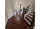 Welcoming foyer with dark hardwood floors, a staircase, and a view of the front door at 8011 Caliterra Dr, Charlotte, NC 28227
