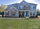 Charming two-story home with stone accents, neat landscaping, and a welcoming blue front door at 8011 Caliterra Dr, Charlotte, NC 28227