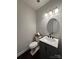 A modern powder room featuring a gray vanity with a marble countertop and updated fixtures at 8011 Caliterra Dr, Charlotte, NC 28227