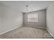 Cozy bedroom features neutral carpet, a window and modern chandelier at 8230 Rudolph Rd, Charlotte, NC 28216