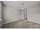 Comfortable bedroom features neutral walls, carpet, and an updated chandelier at 8230 Rudolph Rd, Charlotte, NC 28216
