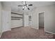 Large bedroom with carpet flooring, a fan, built-in shelving, and closet at 8230 Rudolph Rd, Charlotte, NC 28216