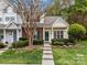 Charming townhome with brick and siding, green door and shutters, and landscaped front yard at 8230 Rudolph Rd, Charlotte, NC 28216