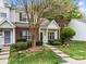 Charming townhome with brick and siding, green door and shutters, and landscaped front yard at 8230 Rudolph Rd, Charlotte, NC 28216