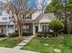 Charming townhome featuring a well-maintained lawn and landscaped front yard with a brick accent at 8230 Rudolph Rd, Charlotte, NC 28216